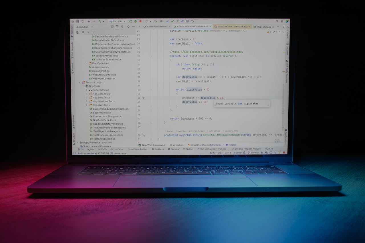 services-02 Close-up of a laptop showing code editor under vibrant lighting, ideal for tech themes.